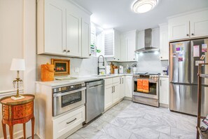 A modern kitchen with white cabinetry, stainless steel appliances, and a marble floor. - 4 Mi to Dtwn: Spacious Suite in Mount Airy (Mount Airy)