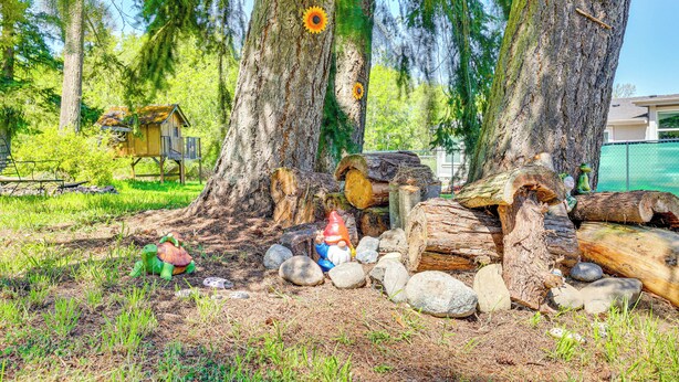 A rustic outdoor setting with a wooden structure, a gnome statue, and a turtle toy.
