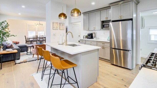 A modern kitchen with stainless steel appliances, a central island with bar stools, and pendant lighting. - Hudson Valley Vacation Rental: Near Hiking (Beacon)