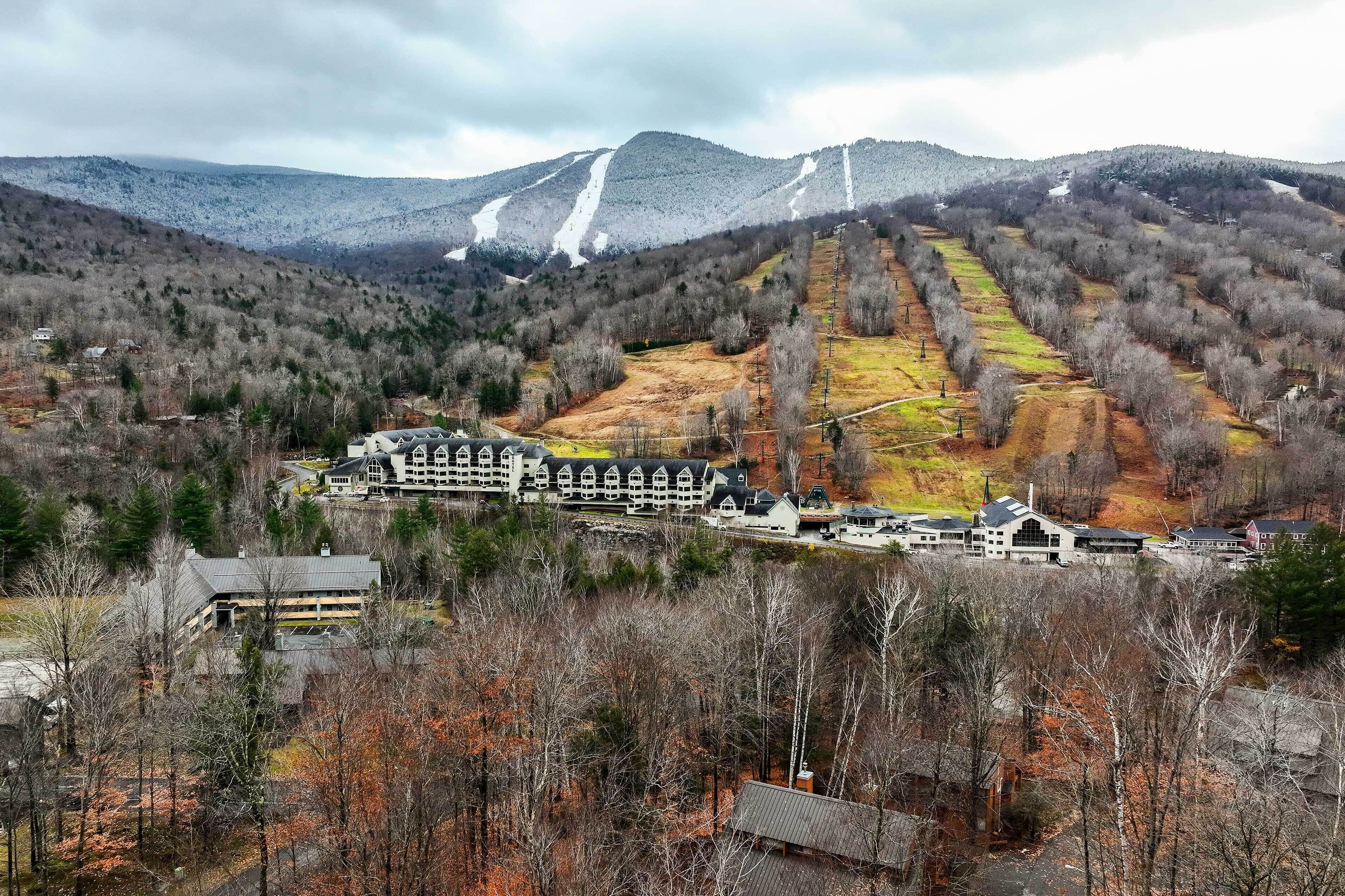 Un paisaje montañoso con una estación de esquí y un albergue con varias edificaciones.