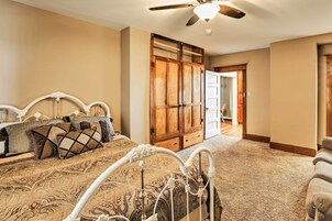 A bedroom with a bed, a wardrobe, and a ceiling fan.