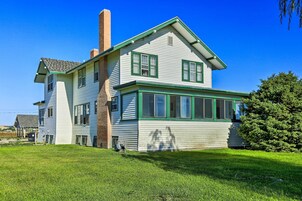 A two-story house with a green trim and a chimney.