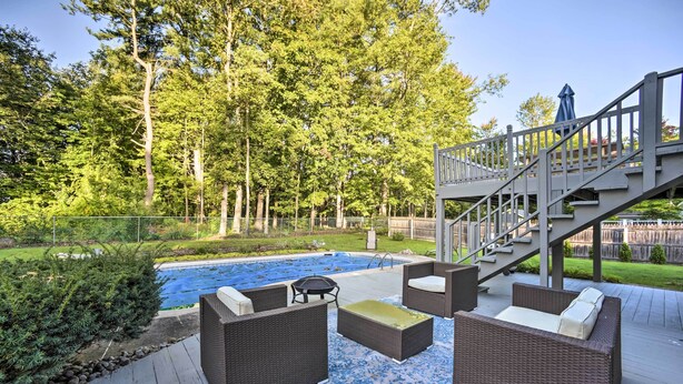 A deck with wicker furniture, a pool, and a staircase leading to a deck. - Updated Home w/ Pool + Deck ~ 2 Mi to Dtwn! (Saratoga Springs)