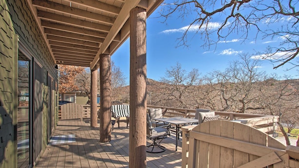 Eine Holzdielen-Terrasse mit überdachter Sitzgelegenheit, einem Tisch und Stühlen.