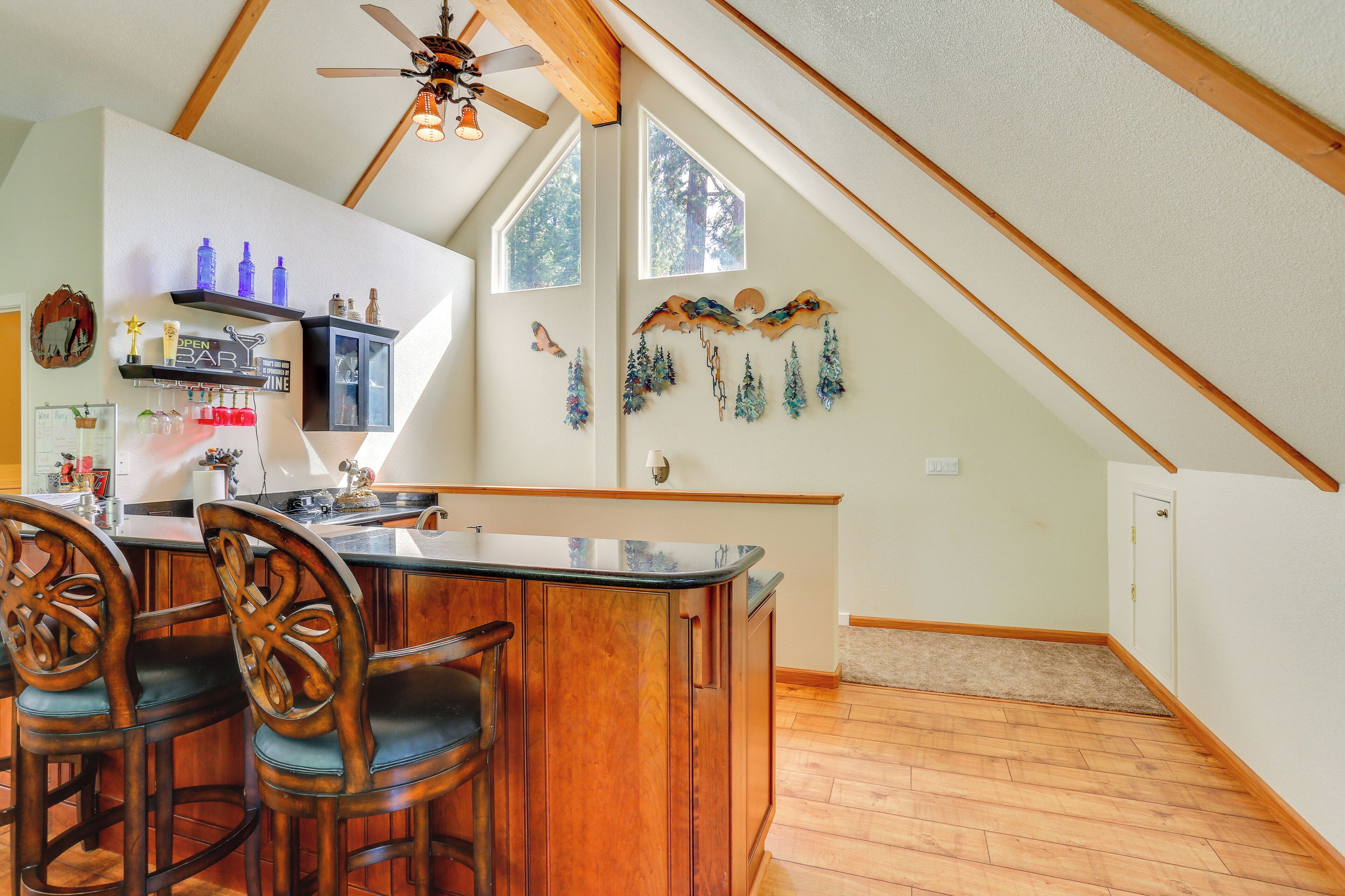 A kitchen with wooden cabinets, a bar area, and a ceiling fan.