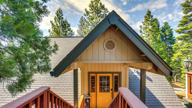 A wooden cabin with a gabled roof, a front door, and a wooden staircase leading to the entrance. - Pet-friendly California Cabin w/ Beach Access (Chester)