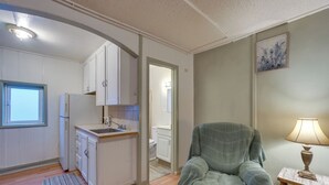 A compact living space with a kitchenette, a dining area, and a bathroom.