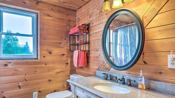 A wooden cabin bathroom with a window, a sink, a toilet, and a mirror. - West Danville Cabin: Day Trip to Stowe Mtn! (West Danville)