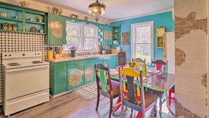 A kitchen with teal cabinetry, a white stove, and a dining table with colorful chairs. - Colorful Bakersville Cottage: Views, Pets Allowed! (Bakersville)