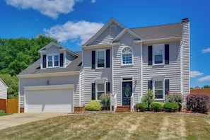 A two-story house with a garage, a front porch, and a well-maintained lawn. - Graham Home w/ Private Pool & Ping-pong Table! (Graham)