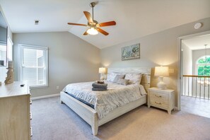 A bedroom with a bed, nightstands, a ceiling fan, a window, and a painting on the wall. - Graham Home w/ Private Pool & Ping-pong Table! (Graham)