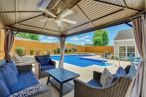 A covered patio area with outdoor furniture, a swimming pool, and a view of the backyard. - Graham Home w/ Private Pool & Ping-pong Table! (Graham)