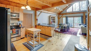 A wooden cabin interior with a kitchen, dining area, and large windows. - 'luna Stella' - West Dover Home 1 Mi to Mt Snow! (West Dover)