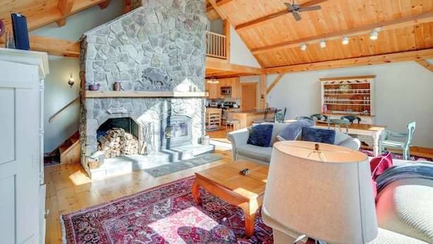 A spacious living room with a stone fireplace, wooden ceiling beams, and a cozy seating area. - 'luna Stella' - West Dover Home 1 Mi to Mt Snow! (West Dover)