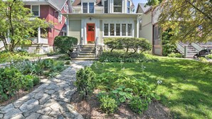 A two-story house with a red door, a stone pathway, and a well-maintained garden. - Classic Oak Park Home, 11 Mi to Downtown Chicago! (Oak Park)