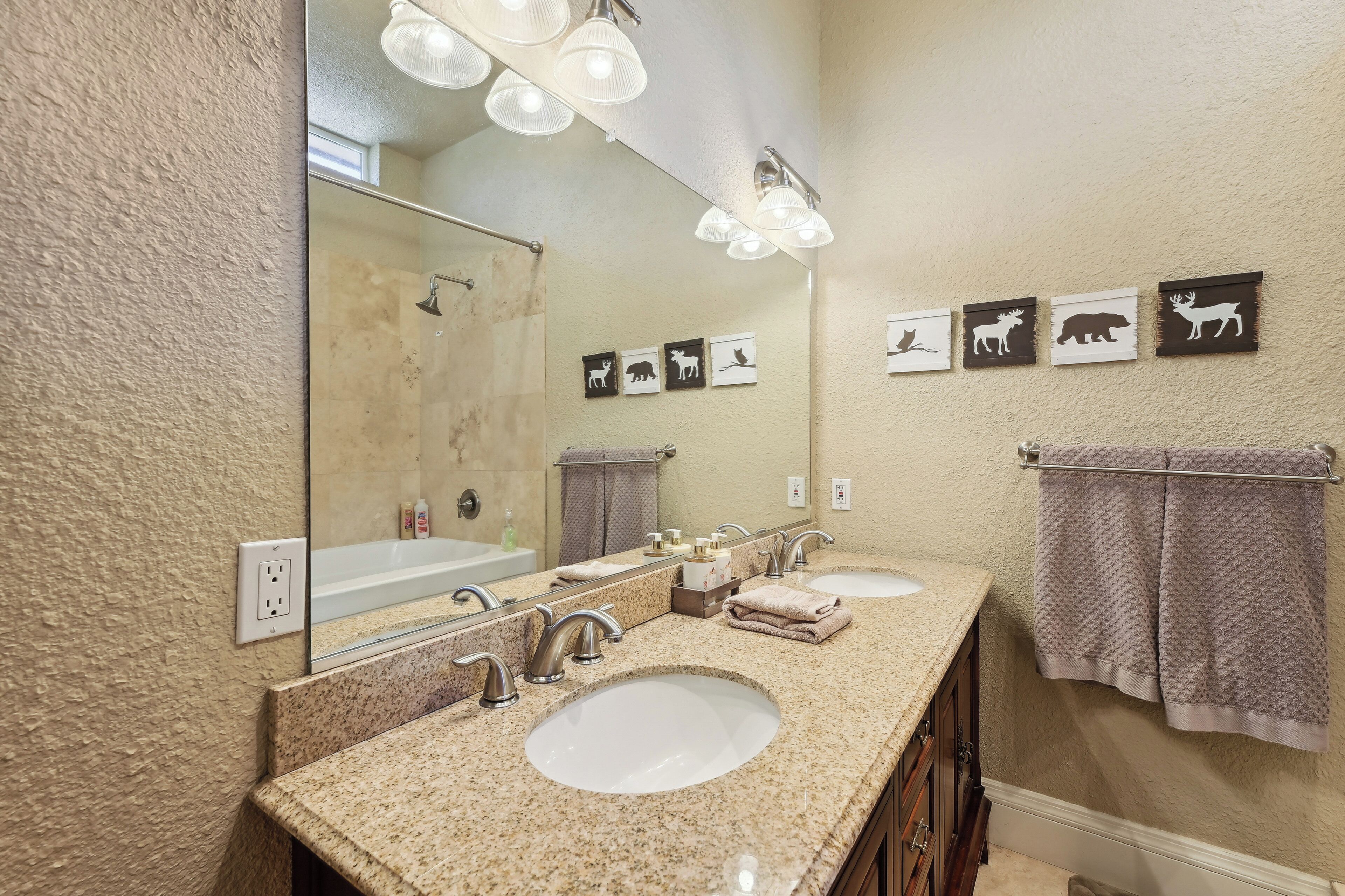 A bathroom with two sinks, a large mirror, and wall-mounted towel racks.