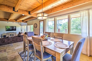 A spacious dining area with a wooden table, chairs, and a chandelier. - Luxury Auberry Retreat in Sierra National Forest (Auberry)