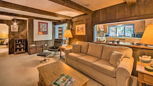 A cozy living room with a sofa, coffee table, and a bookshelf.