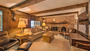 A cozy living room with a fireplace, leather sofas, and wooden furniture.