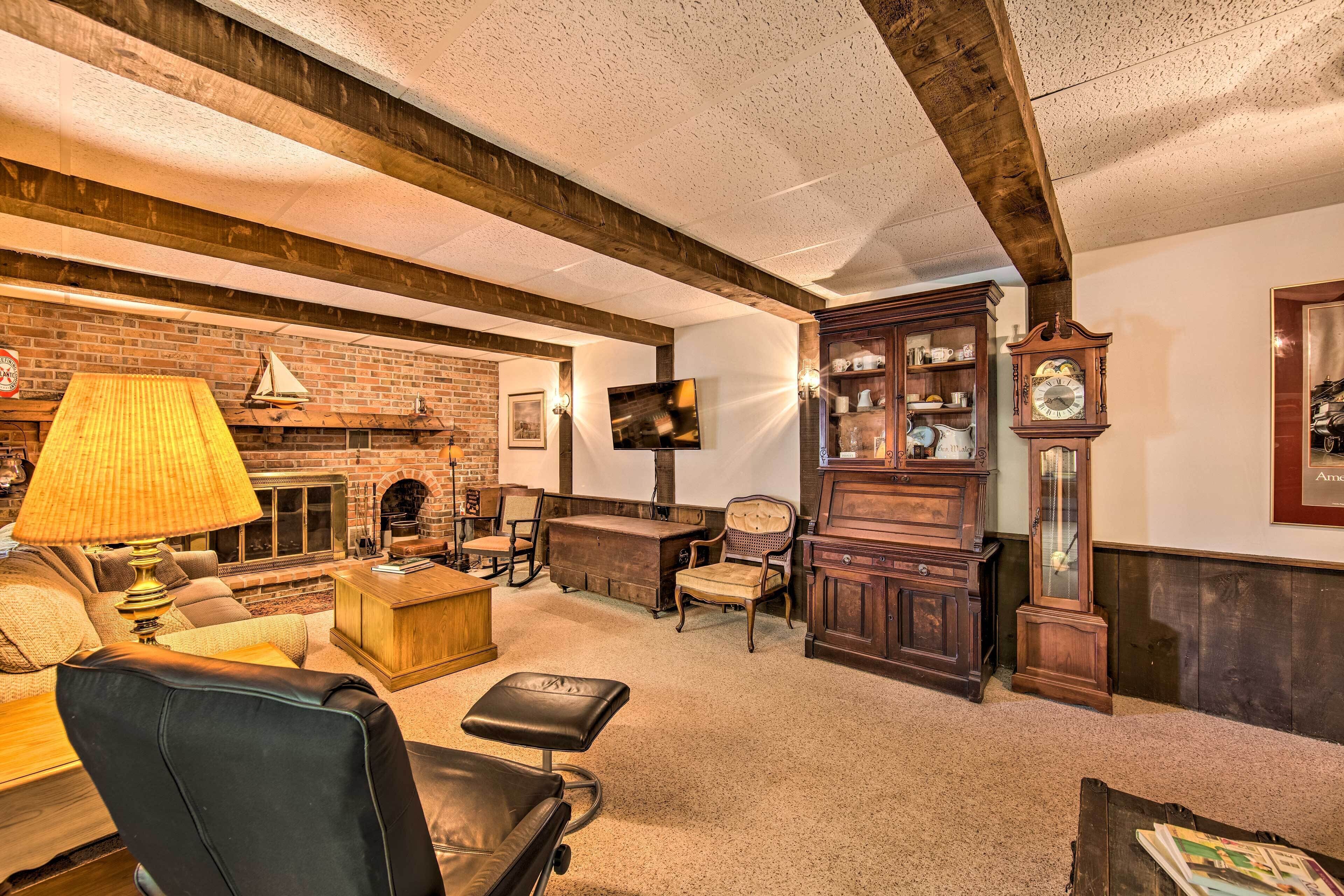 A cozy living room with a fireplace, leather furniture, and a wooden cabinet.