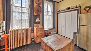 A kitchen with wooden cabinets, a refrigerator, a wooden table, and a radiator. - Vintage Apartment in Historic Downtown La Porte (La Porte)
