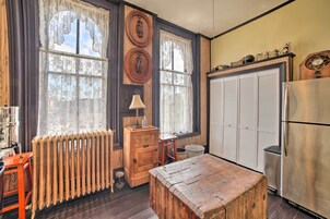 Una cocina con armarios de madera, un refrigerador, una mesa de madera y un radiador.