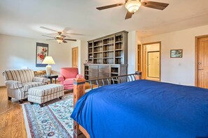A bedroom with a large bed, a ceiling fan, a bookshelf, a chair, and a rug. - Wilmington Home on 18 Acres ~ 9 Mi to Skiing! (Wilmington)