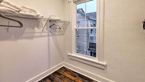 Ein Blick in einen Raum, mit Fenster, Wäscheständer aus Metall und Holzboden.