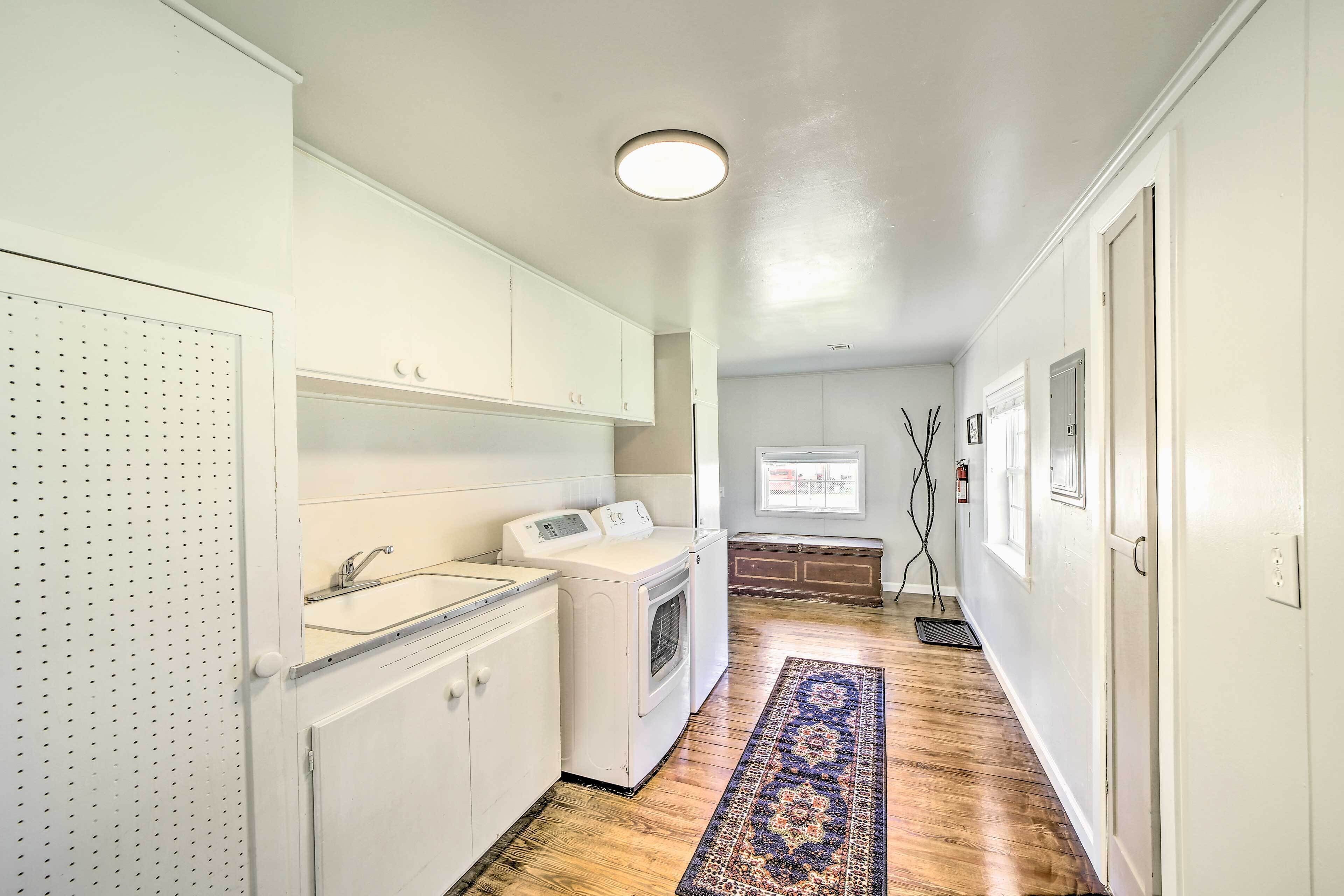 A laundry area with a washing machine, dryer, and a sink.