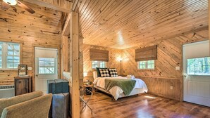 Une chambre confortable, aménagée dans un chalet en bois, avec un lit, une chaise et une petite table.
