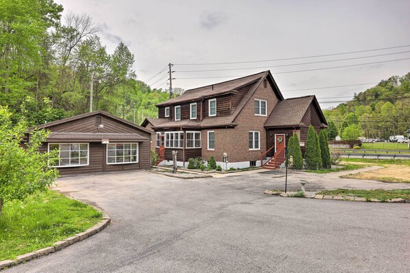 A two-story house with a garage, surrounded by greenery and a paved driveway. - 'lynn' Dog-friendly Abode w/ Mountain Views! (Hagerhill)