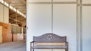 A bench in a covered outdoor area with a metal roof and wooden walls. - Georgetown Barn Studio on > 7 Acres: Pet Friendly! (Georgetown)