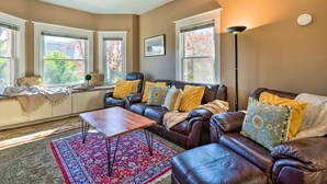 A cozy living room with a brown leather sofa, a wooden coffee table, and a red patterned rug. - Salt Lake City Condo < 28 Mi to Ski Resort! (Salt Lake City)