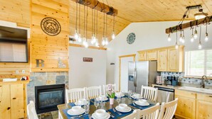 A cozy, well-lit kitchen with wooden cabinets, a built-in oven, and a dining area set for a meal.