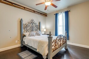 A bedroom with a bed, a ceiling fan, a window with curtains, and a nightstand. - Countryside Retreat! Spacious Home in La Vernia (Adkins)