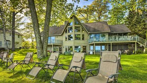 Une grande maison dotée d’un balcon et de plusieurs fauteuils de jardin dans la cour.