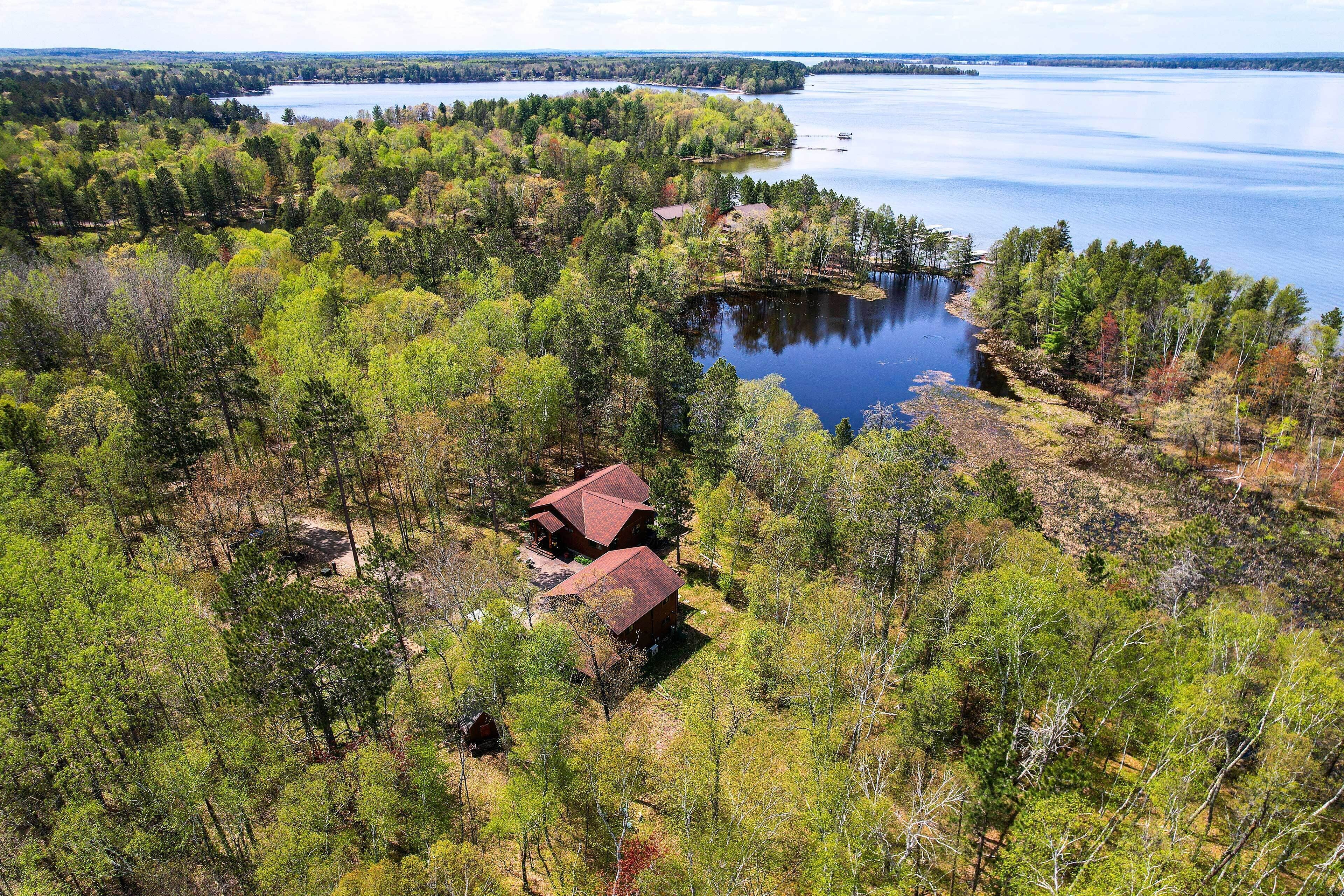 A remote cabin surrounded by dense forest and a lake.