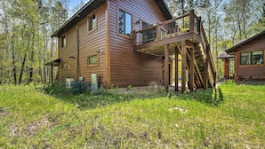 A wooden cabin with a balcony, surrounded by trees. - Waterfront Escape w/ Fire Pit in Crosslake! (Pequot Lakes)