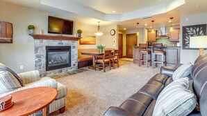 A spacious living room with a fireplace, a dining area, and a kitchen. - Central Mccall Getaway: Walk to Payette Lake! (McCall)