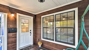 A wooden exterior with a white door, a large window with blinds, and a welcome mat. - Lovely Historic Fort Worth Home w/ Deck (Fort Worth)