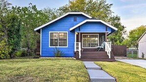 A blue house with a front porch, a small front yard, and a wooden fence. - Lovely Historic Fort Worth Home w/ Deck (Fort Worth)