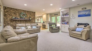 Ein geräumiges Wohnzimmer mit Ledersofas, einem Kamin und einer Küche im Hintergrund.