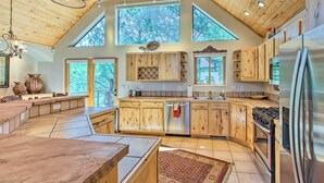 Eine geräumige Küche mit Holzausstattung, einem Edelstahlkühlschrank und einer großen Kücheninsel.
