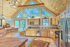 Eine geräumige Küche mit Holzausstattung, einem Edelstahlkühlschrank und einer großen Kücheninsel.