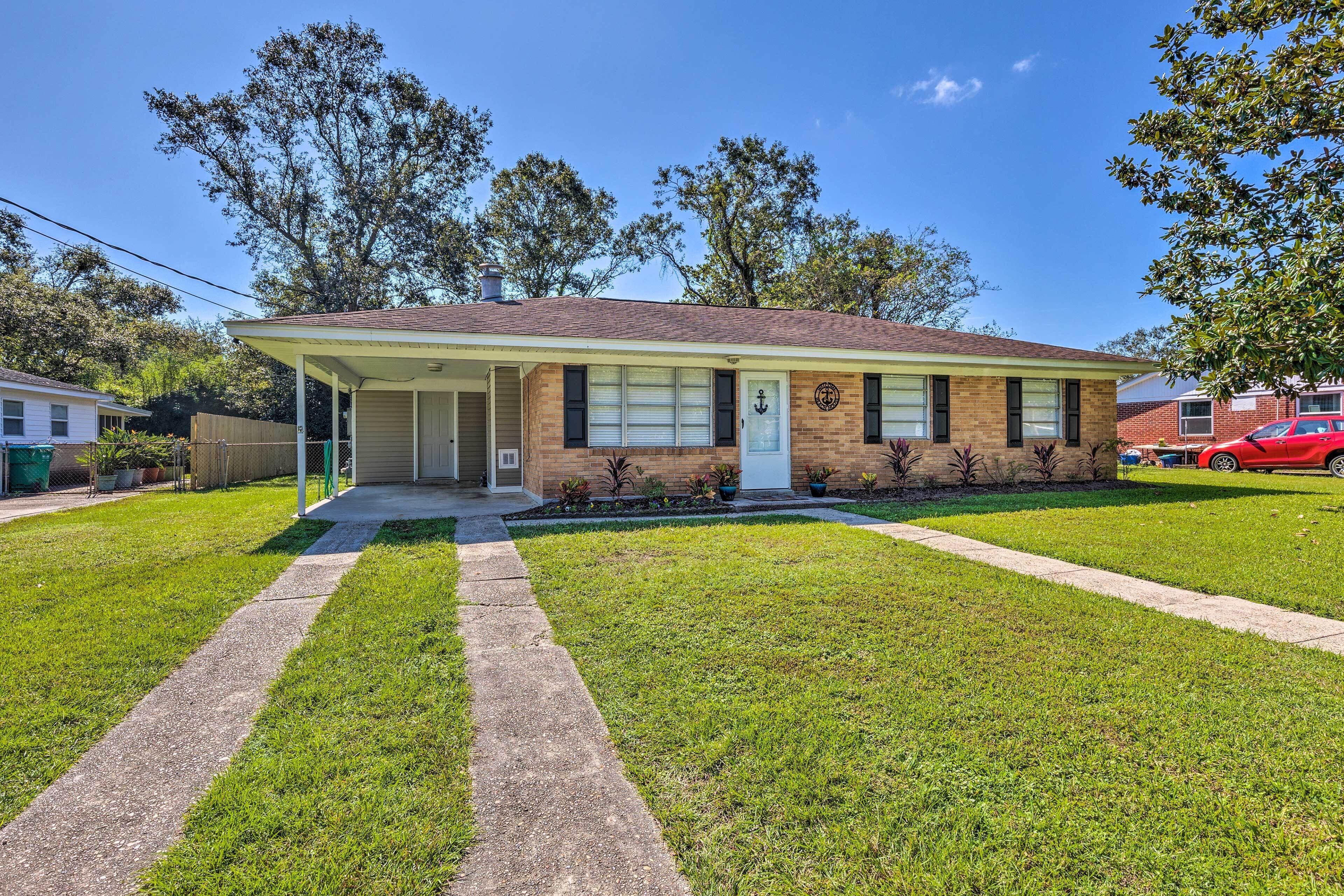 A single-story house with a front porch, a brick exterior, and a small front yard with a lawn and a concrete path.