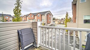 A residential area with multiple townhouses, a balcony with a metal chair, and a clear view of the street. - Sleek Escape w/ Balcony < 1 Mi to 5th Avenue! (Anchorage)