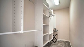 A walk-in closet with white shelving units and a hanging rod. - Sleek Escape w/ Balcony < 1 Mi to 5th Avenue! (Anchorage)