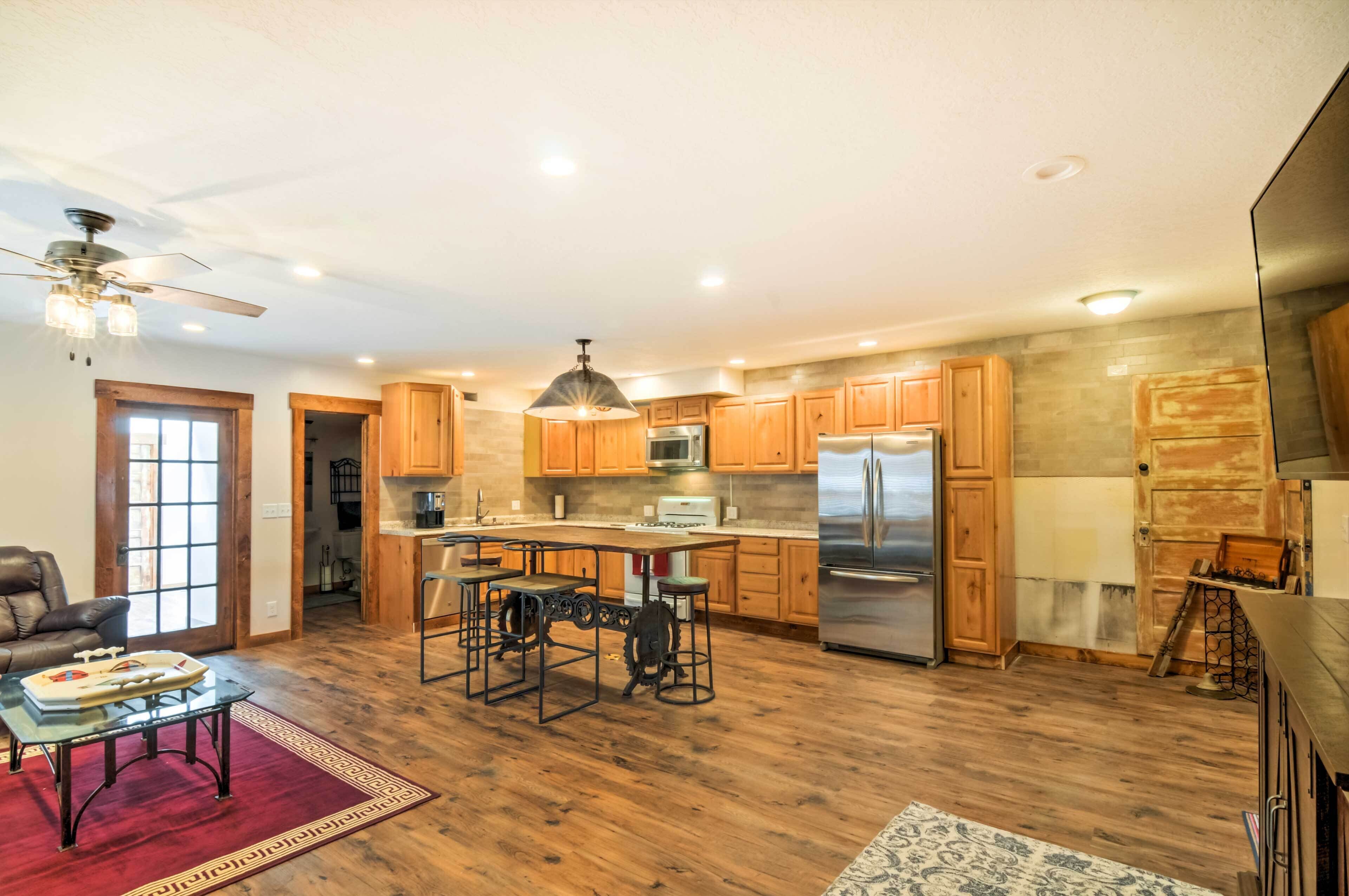 A spacious kitchen with wooden cabinets, a stainless steel refrigerator, and a dining area with a table and chairs.