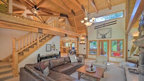 A spacious living area with a wooden staircase, leather sofa, and a dining area. - 'wild Huckleberry Cabin' in Alpine: Fire Pit, Deck (Alpine)