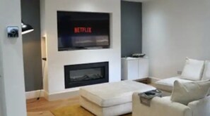 Relax and unwind in this stylish living room, featuring a wall-mounted TV, comfortable sofa, and coffee table.